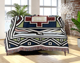 Ndebele Tribal Cotton Throw Blanket in Blue, Green and Red, draped over a sofa