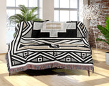 Ndebele Tribal Cotton Throw Blanket in Beige and Gray, draped over a sofa
