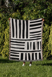 Pereto Abstract Print Cotton Throw Blanket in Black, outdoors