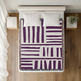 Pereto Abstract Print Cotton Throw Blanket in Purple, on a bed
