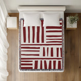 Pereto Abstract Print Cotton Throw Blanket in Red, on a bed