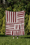 Pereto Abstract Print Cotton Throw Blanket in Red, outdoors