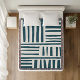 Pereto Abstract Print Cotton Throw Blanket in Teal, on a bed