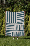 Pereto Abstract Print Cotton Throw Blanket in Teal, outdoors