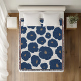 Poppi Floral Cotton Throw Blanket in Blue, on a bed