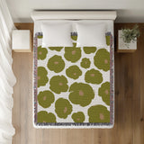 Poppi Floral Cotton Throw Blanket in Chartreuse, on a bed