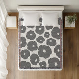 Poppi Floral Cotton Throw Blanket in Gray, on a bed