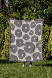 Poppi Floral Cotton Throw Blanket in Gray, outdoors
