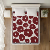 Poppi Floral Cotton Throw Blanket in Red, on a bed
