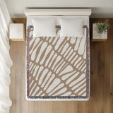 Pyro Abstract Print Cotton Throw Blanket in Beige, on a bed