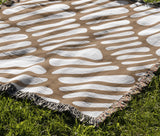 Pyro Abstract Print Cotton Throw Blanket in Beige, outdoors