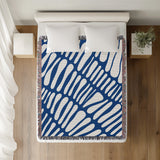 Pyro Abstract Print Cotton Throw Blanket in Blue, on a bed