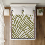 Pyro Abstract Print Cotton Throw Blanket in Chartreuse, on a bed