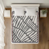 Pyro Abstract Print Cotton Throw Blanket in Gray, on a bed