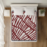 Pyro Abstract Print Cotton Throw Blanket in Red, on a bed