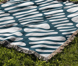 Pyro Abstract Print Cotton Throw Blanket in Teal, outdoors