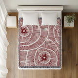 Ray Abstract Print Cotton Throw Blanket in Red, on a bed