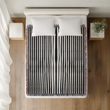 River Striped Cotton Throw Blanket in Black, on a bed