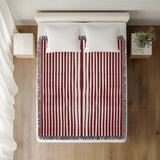 River Striped Cotton Throw Blanket in Red, on a bed