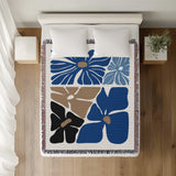 Roni Floral Cotton Throw Blanket in Blue, on a bed