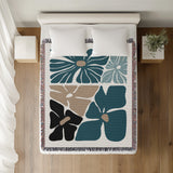 Roni Floral Cotton Throw Blanket in Teal, on a bed