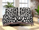 Sani Cheetah Print Cotton Throw Blanket in Black and Off-White, draped over a sofa
