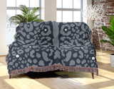 Sani Cheetah Print Cotton Throw Blanket in Blue Gray, draped over a sofa