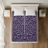 Sani Cheetah Print Cotton Throw Blanket in Lilac, on a bed