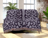 Sani Cheetah Print Cotton Throw Blanket in Lilac, draped over a sofa