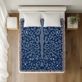 Sani Cheetah Print Cotton Throw Blanket in Navy Blue and Blue, on a bed