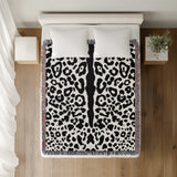 Sani Cheetah Print Cotton Throw Blanket in Off-White and Black, on a bed