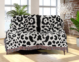 Sani Cheetah Print Cotton Throw Blanket in Off-White and Black, draped over a sofa