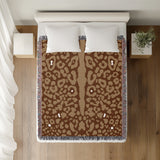 Sani Cheetah Print Cotton Throw Blanket in Rust Brown and Beige, on a bed