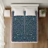 Sani Cheetah Print Cotton Throw Blanket in Teal, on a bed