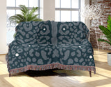 Sani Cheetah Print Cotton Throw Blanket in Teal, draped over a sofa