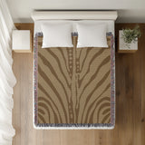 Sasha Zebra Print Cotton Throw Blanket in Beige and Brown, on a bed