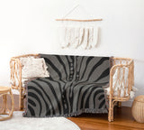 Sasha Zebra Print Cotton Throw Blanket in Gray, draped over a sofa