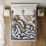 Sassi Animal Print Cotton Throw Blanket in Gray, Beige and Blue, on a bed