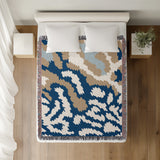 Sassi Animal Print Cotton Throw Blanket in Navy Blue, Beige and Blue, on a bed