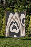 Shai Animal Print Cotton Throw Blanket in Gray and Beige, draped over a sofa