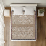 Thora Tribal Cotton Throw Blanket in Beige, on a bed