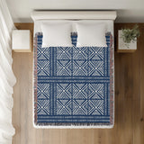 Thora Tribal Cotton Throw Blanket in Blue, on a bed