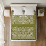 Thora Tribal Cotton Throw Blanket in Chartreuse, on a bed