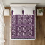 Thora Tribal Cotton Throw Blanket in Purple, on a bed