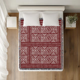 Thora Tribal Cotton Throw Blanket in Red, on a bed