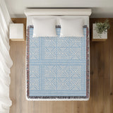 Thora Tribal Cotton Throw Blanket in Sky, on a bed