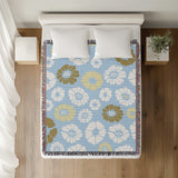Valu Floral Cotton Throw Blanket in Sky, on a bed