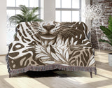 Fiero Leopard Cotton Blend Blanket Throw in Beige and Off-White, draped over a chair