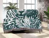 Fiero Leopard Cotton Blend Blanket Throw in Teal and Off-White, draped over a chair