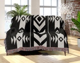 Fika Southwestern Cotton Blend Blanket Throw in Black and Off-White, draped over a chair